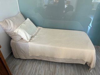 Cama individual Zara Home con ropa y cojines