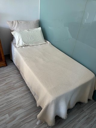Cama individual Zara Home con ropa y cojines