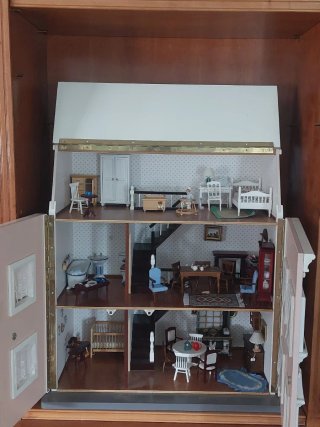 Casa de muñecas rosa con ventanas y con muebles