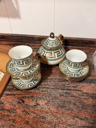 Tetera de porcelana con tazas y platillos