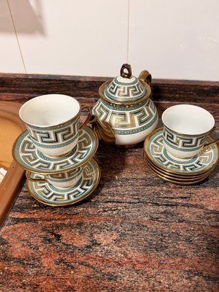 Tetera de porcelana con tazas y platillos
