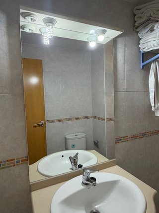 Mueble de baño con lavabo, espejo y grifería