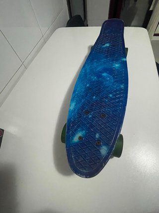 Monopatín azul con ruedas verdes