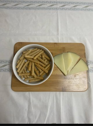 Tabla de quesos con cuenco y cuchillos