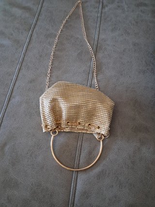Bolso de mano dorado con cadena
