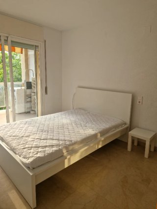 Cama individual blanca con mesita