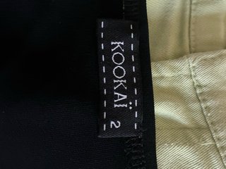 Top Kokai negro y pantalón verde