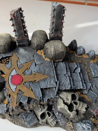 Base di scena con tema rovine e teschi, simbolo del Caos Warhammer