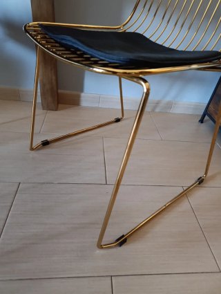 Silla metálica dorada con cojín negro