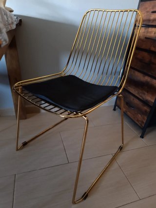 Silla metálica dorada con cojín negro