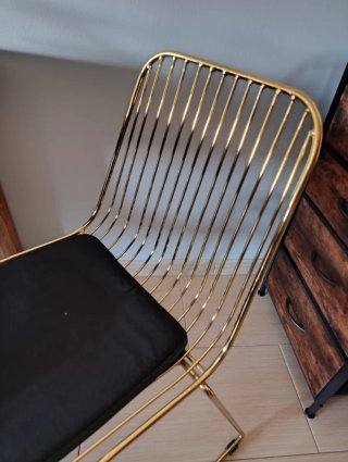 Silla metálica dorada con cojín negro