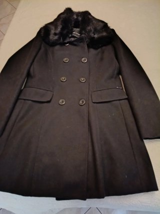 Cappotto nero con collo in pelliccia sintetica.