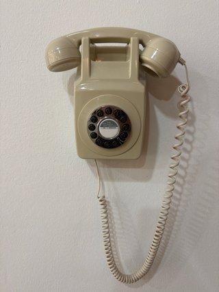 Teléfono antiguo beige pared