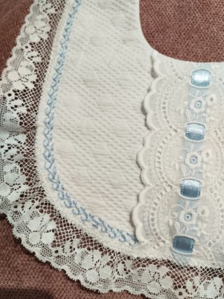 Babero blanco con encaje y bordado azul
