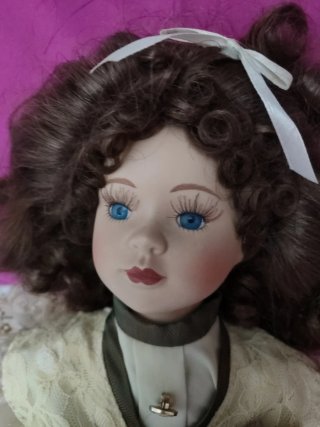Muñeca de porcelana con vestido y bolso