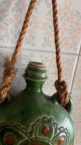 Botijo de cerámica verde con diseño floral
