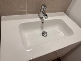 Mueble de lavabo blanco y metal junto con el grifo