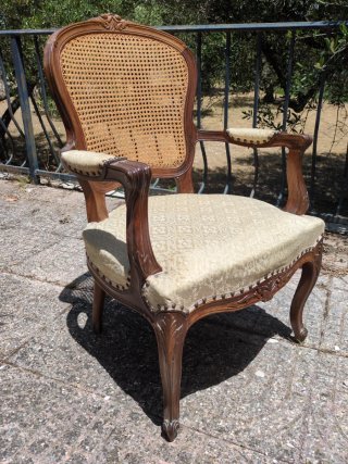 Sillón de madera con asiento de ratán.