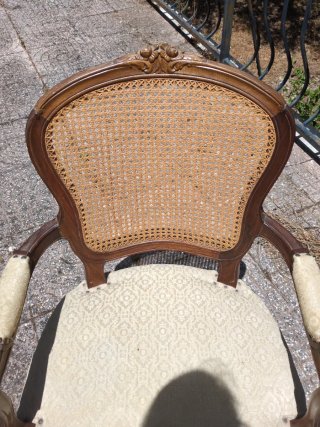 Sillón de madera con asiento de ratán.