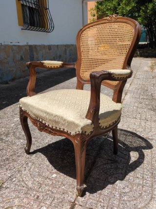 Sillón de madera con asiento de ratán.
