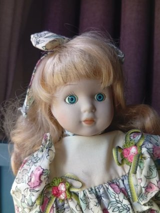Muñeca de porcelana antigua con vestido floral