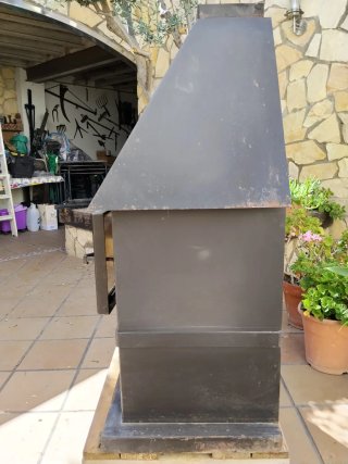 Estufa de leña negra con puerta de cristal