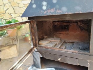 Estufa de leña negra con puerta de cristal