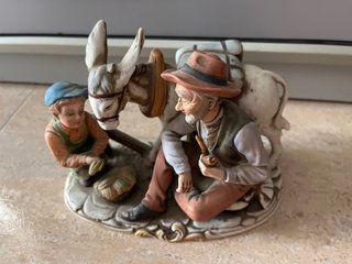 Figura porcelana abuelo y niño con burro