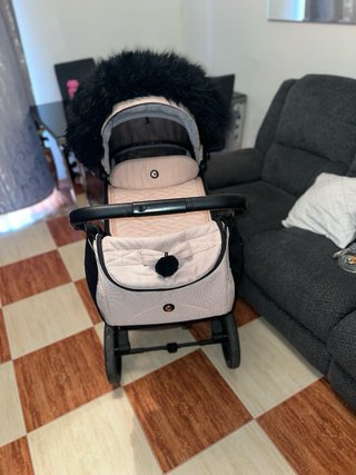 Carro de bebé rosa con capazo y bolso