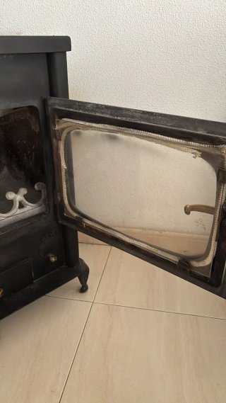 Estufa de leña negra con detalles dorados