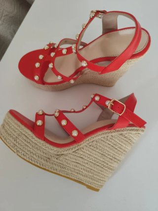 Sandalias rojas con alto tacón de esparto.