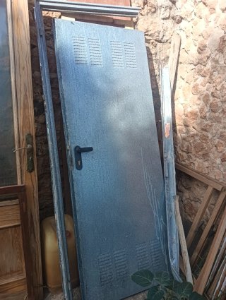 Puerta metálica gris con ventilación