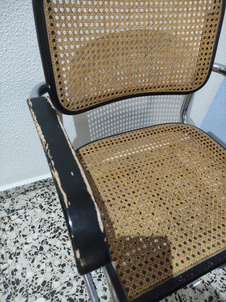 Silla cesca con reposabrazos, metal y ratán.