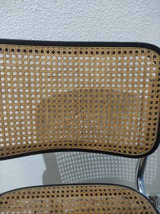 Silla cesca con reposabrazos, metal y ratán.