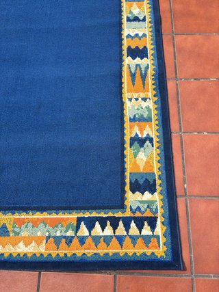 Alfombra azul con borde multicolor