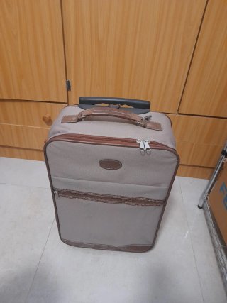 Troler de viaje beige con detalles marrones