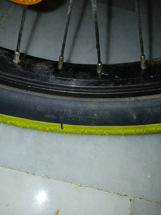 Bicicleta BMX plateada con ruedas amarillas