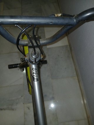 Bicicleta BMX plateada con ruedas amarillas