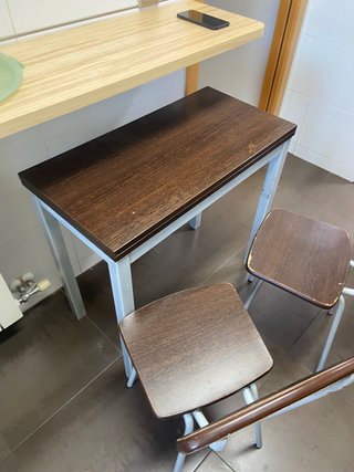 Mesa madera oscura patas metal con dos sillas