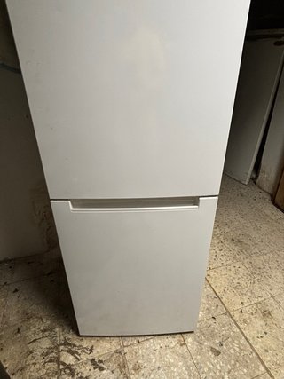 Nevera con estantes de cristal Y congelador.