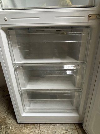 Nevera con estantes de cristal Y congelador.