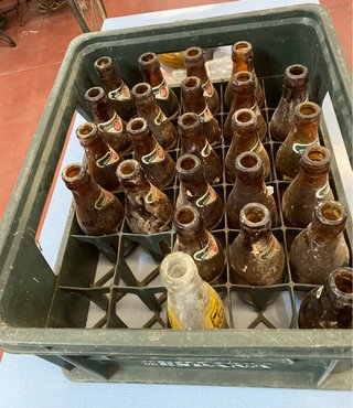 Vecchia scatola di birra El Águila con bottiglie