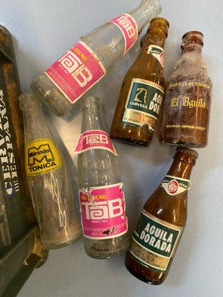 Vecchia scatola di birra El Águila con bottiglie