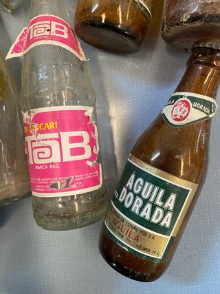 Vecchia scatola di birra El Águila con bottiglie