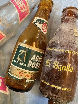 Vecchia scatola di birra El Águila con bottiglie