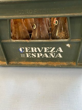 Vecchia scatola di birra El Águila con bottiglie