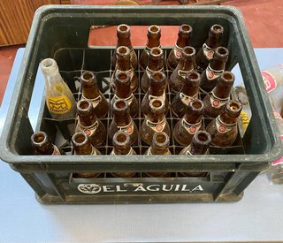 Vecchia scatola di birra El Águila con bottiglie