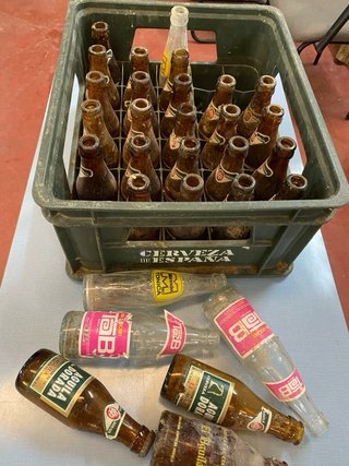 Vecchia scatola di birra El Águila con bottiglie