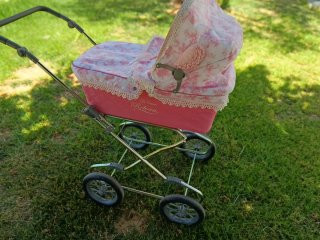 Carro de muñecas rosa con capota floral