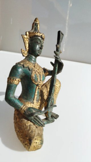 Estatua antigua de bronce. Representa a un músico